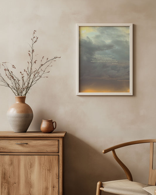 Framed Job 37:14b-16 Scripture art print on a wall above a wooden cabinet with decorative items.