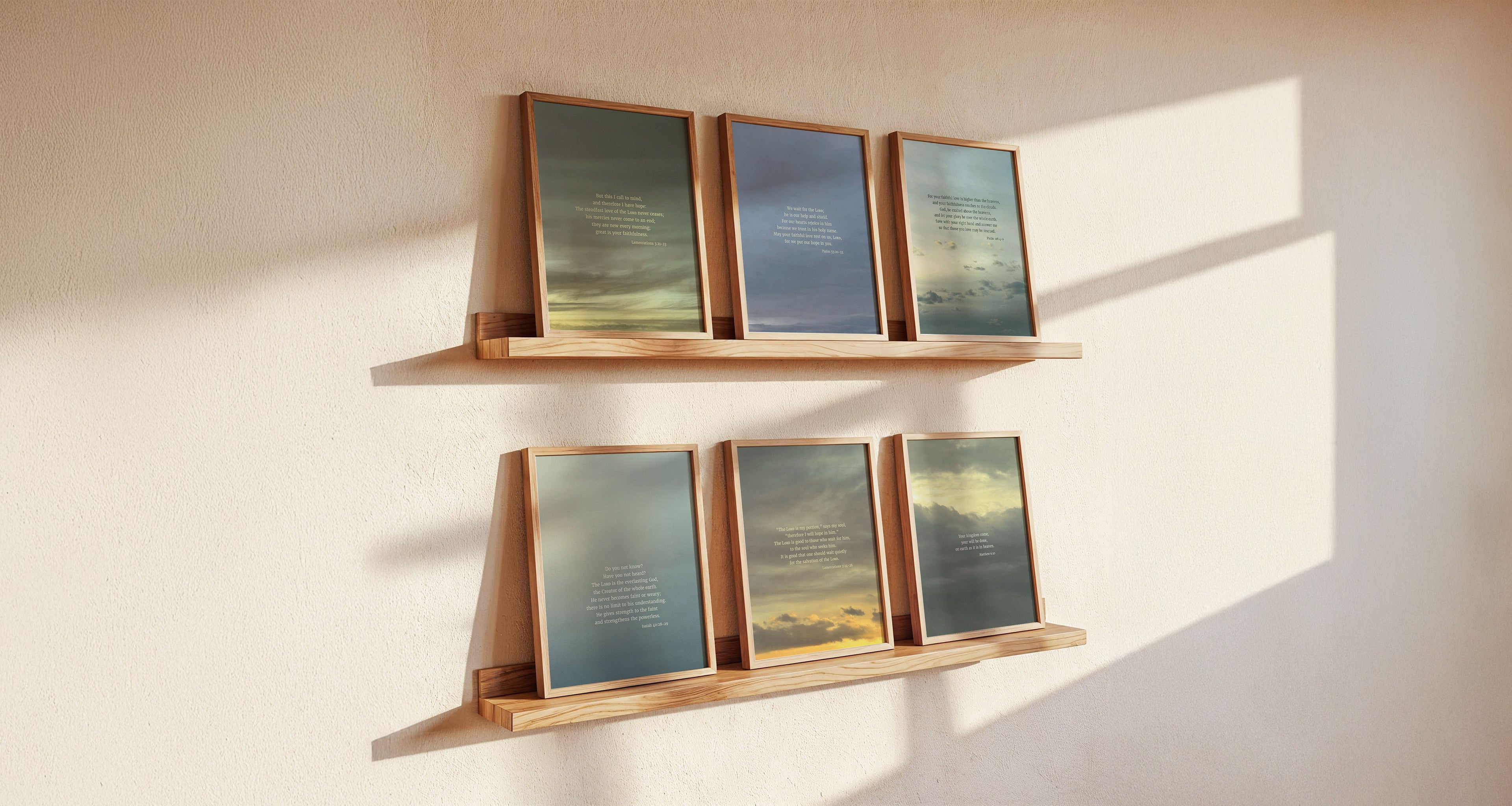 Wooden shelves with framed six Scripture art prints on a light wall with light coming from a window on the right.